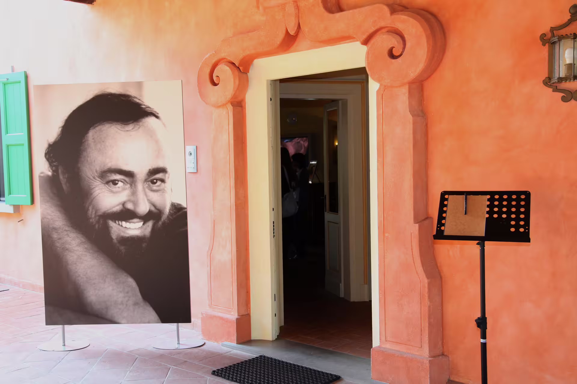 Entrance to Luciano Pavarotti House Museum in Modena with portrait display, included admission ticket