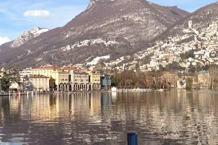 Lugano lakeside waterfront with alpine mountains, scenic viewpoint on guided tour from Como to Switzerland