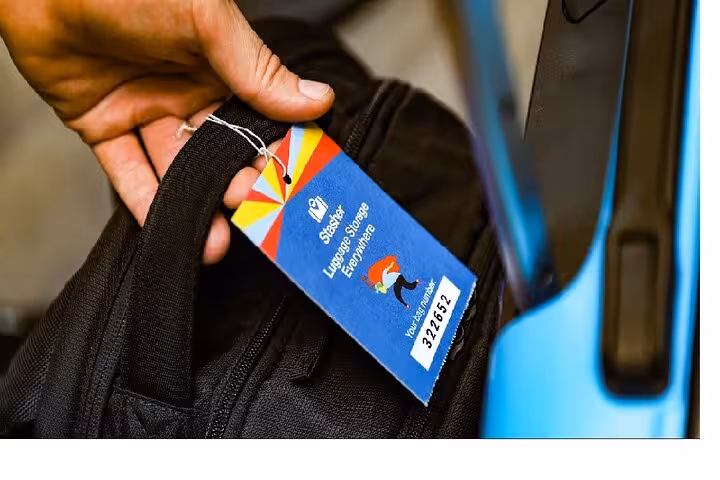 Hand attaching tag to suitcase for secure Brighton luggage storage near Brighton Station and city centre