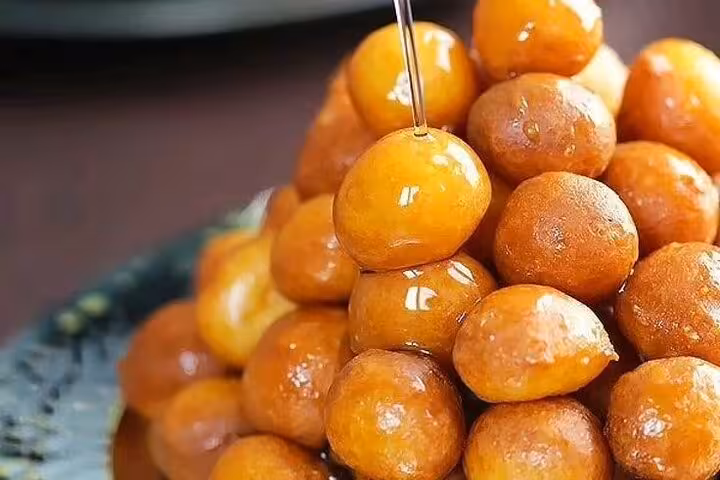 Close-up of syrup-soaked luqaimat street food dessert tasting on a Historic Islamic Cairo walking tour