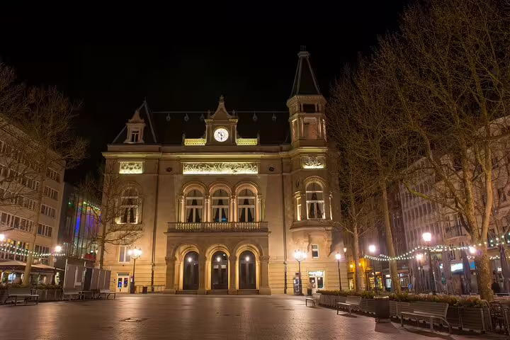 Luxembourg City historic building illuminated at night with clock tower and arched entrance in central plaza