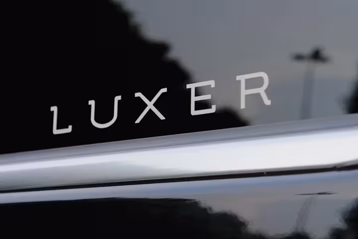 Close-up of Luxer logo on luxury vehicle for Venice to Ravenna cruise terminal transport.