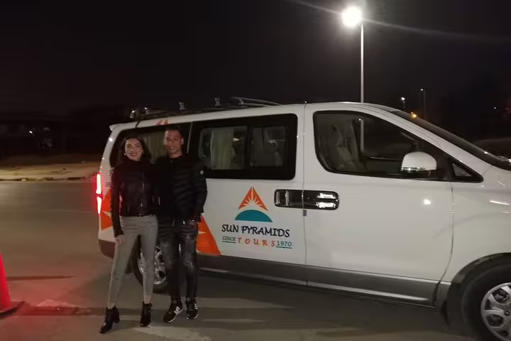 Couple beside private minivan for Luxor Airport private transfer, reliable pickup and drop-off service at night