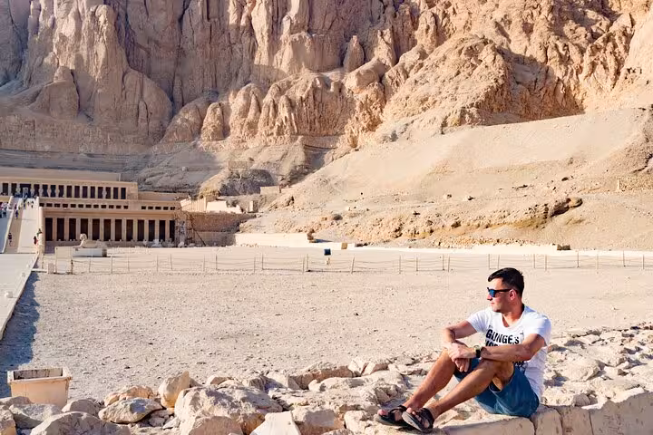 Traveler resting near Hatshepsut Temple at Deir el-Bahari on a private Luxor day tour itinerary
