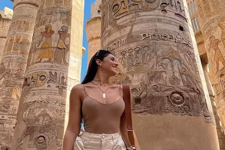 Traveler by Karnak Temple hieroglyph columns on a Luxor day trip from Hurghada with King Tut tomb visit