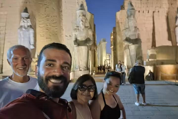 Private guided Luxor East Bank tour selfie at Karnak Temple entrance with towering statues at night