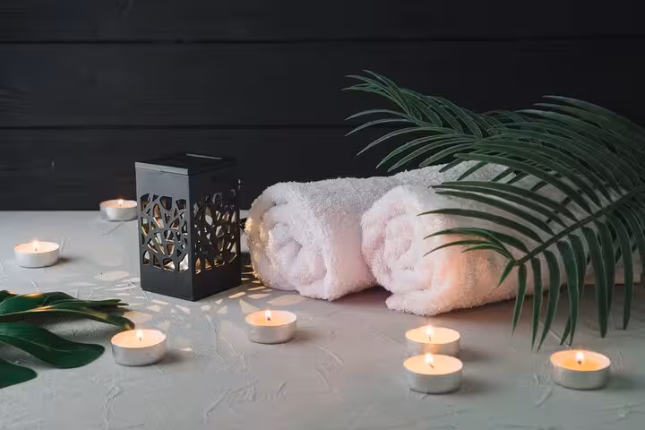 Relaxing Luxor hammam spa setup with rolled towels, candles and lantern for 2-hour massage package