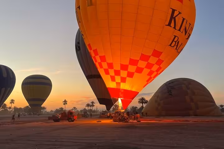 Luxor hot air balloon launch at sunrise with glowing burner, Egypt, hotel pickup & drop-off West Bank flight