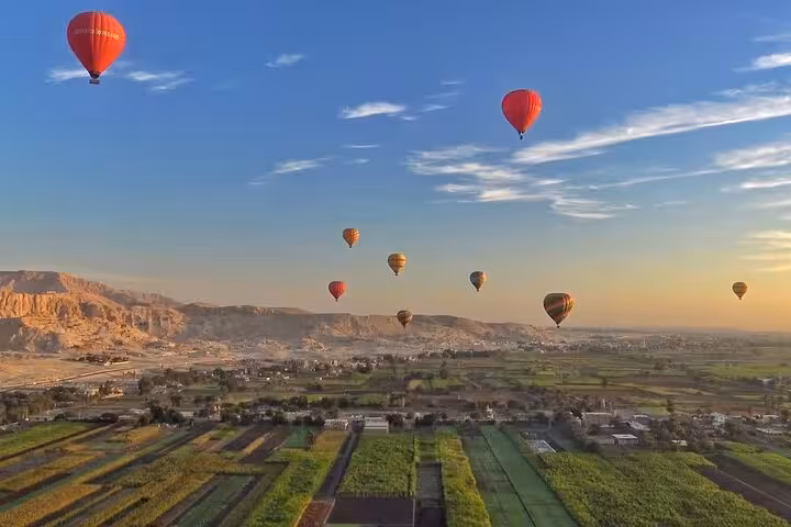Sunrise Luxor hot air balloon ride over Nile Valley farmlands and desert cliffs with hotel transfers