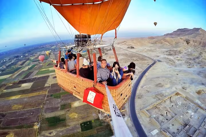 VIP Luxor hot air balloon basket selfie over West Bank fields and desert, sunrise flight with views