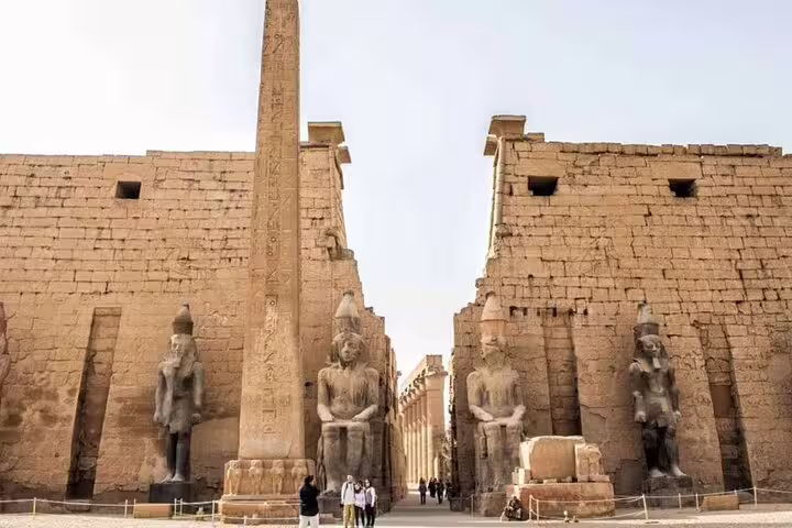 Luxor Karnak Temple entrance with towering obelisk and statues on day trip by plane from Sharm El Sheikh
