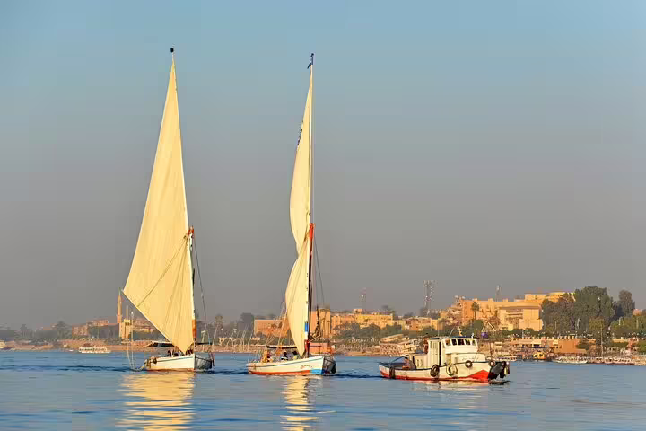 Traditional feluccas sailing the Nile at sunset in Luxor, perfect scenery for a Luxor and Karnak day tour