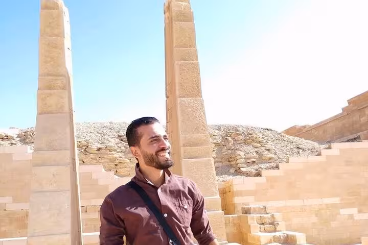 Private Luxor day tour guest by ancient temple pillars, exploring East and West Bank highlights with guide