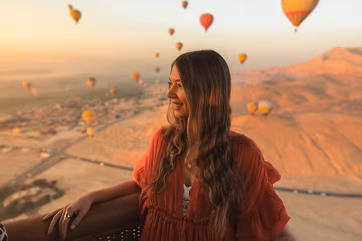 Traveler enjoying Luxor sunrise hot air balloon ride over the Nile Valley with hotel pickup and drop-off