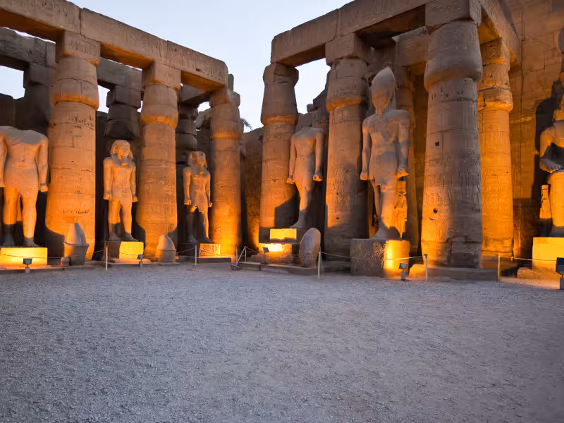Luxor Temple colonnade lit at dusk, ancient Egypt sightseeing on the Timeless Egypt & Jordan tour package