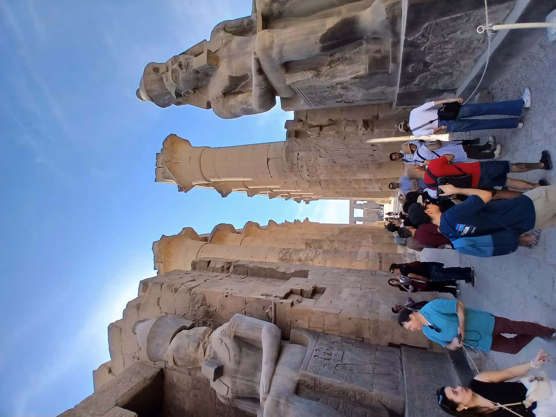 Tourists admire the colossal statues at Luxor Temple, capturing the grandeur of ancient Egyptian architecture and history.