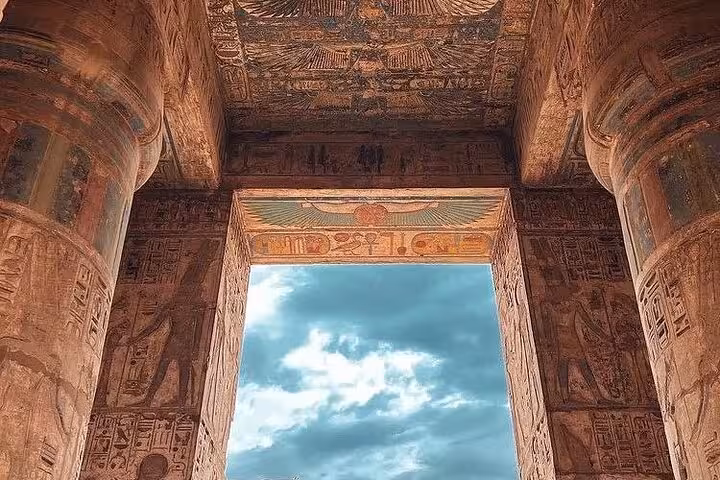 Painted ceiling and towering columns framing sky at Luxor temple, private tour from Marsa Alam Egypt