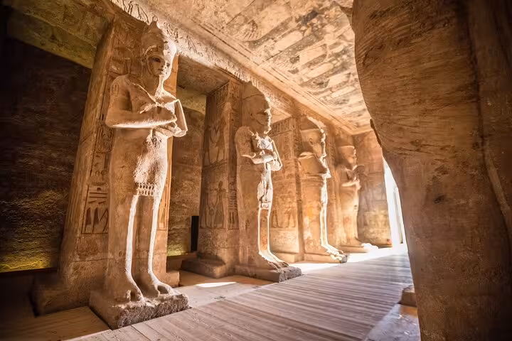 Inside Luxor temple corridor with ancient Egyptian statues and hieroglyphs on a private 2-day tour from Hurghada