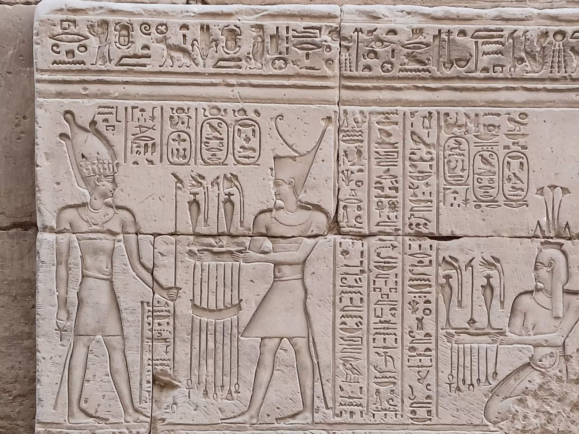 Ancient hieroglyphics and carvings on Luxor temple walls showcasing Egyptian pharaohs and deities.