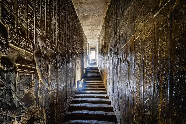 Ancient Egyptian temple corridor with carved hieroglyphs in Luxor, visited on Cairo to Luxor sleeper train tour