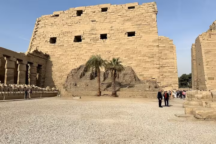Tourists at Luxor Temple courtyard on Hurghada day trip, exploring ancient sandstone walls and ruins