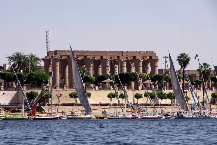 Nile River feluccas in front of Luxor Temple on a private full-day car tour from Aswan, Egypt