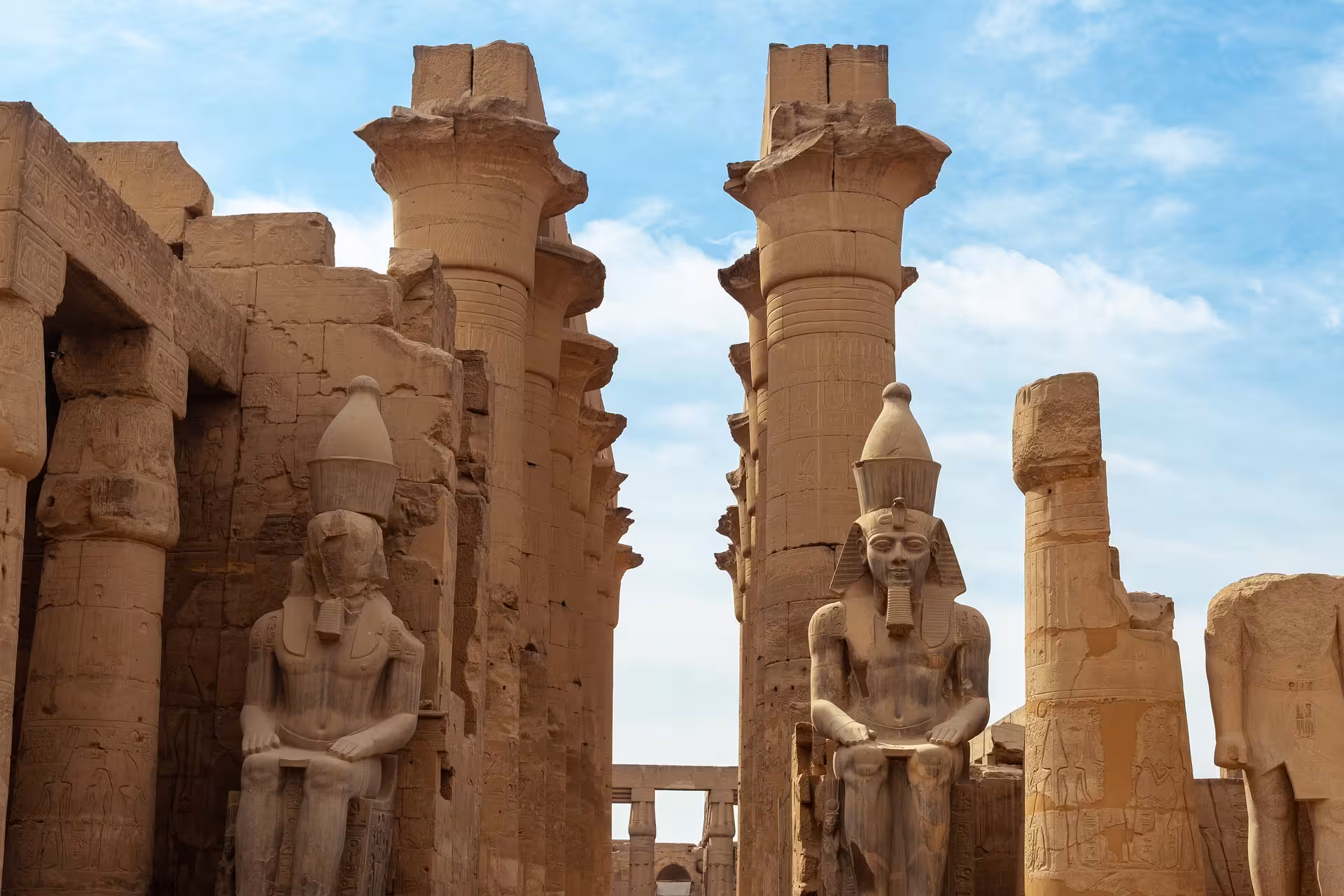 Colossal seated pharaoh statues and papyrus columns at Luxor Temple, Egypt