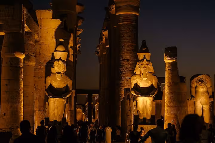 Illuminated Luxor Temple statues at night on full-day semi-private tour from Hurghada with entrance tickets