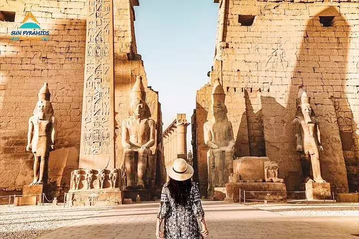 Visitor facing Luxor Temple statues and obelisk, private full-day tour from Aswan to Luxor by car, Egypt