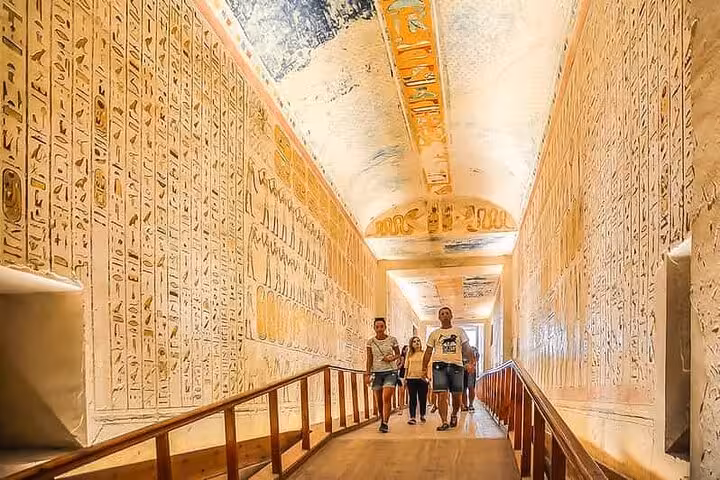 Guided walk through a hieroglyph-lined tomb corridor on a full-day Luxor semi-private tour from Hurghada
