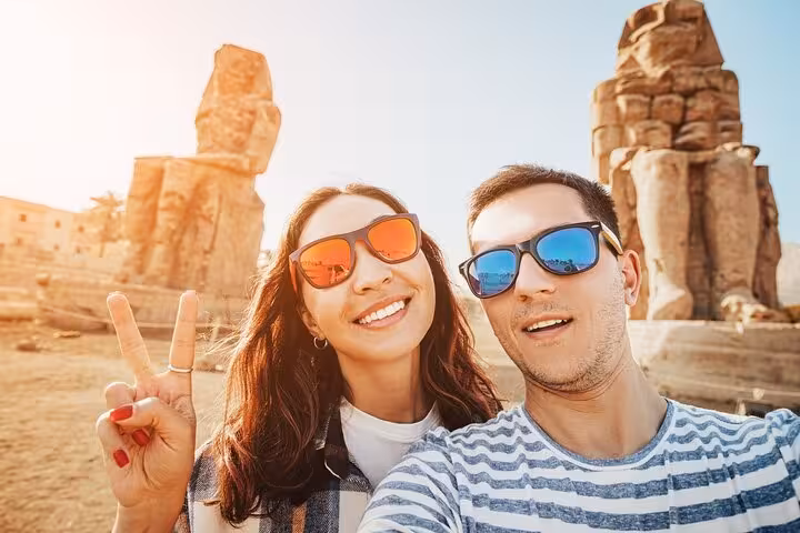 Couple selfie by Colossi of Memnon, Luxor on Hurghada 2-day tour with hotel accommodation, balloon and Nile boat