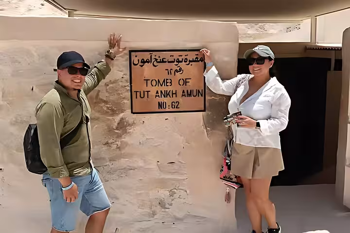Visitors by the Tomb of Tutankhamun sign in Valley of the Kings on Luxor highlights tour from Hurghada with lunch