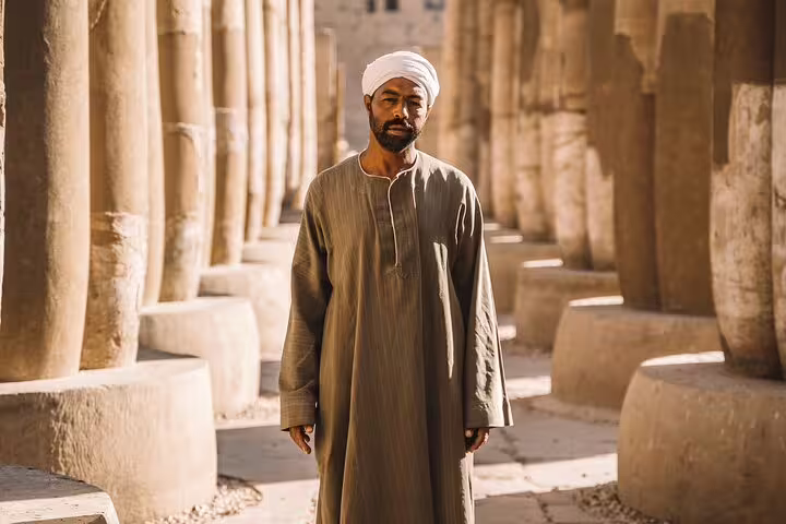 Local guide in traditional galabeya among ancient temple columns in Luxor on a 3 days 2 nights VIP train tour from Cairo