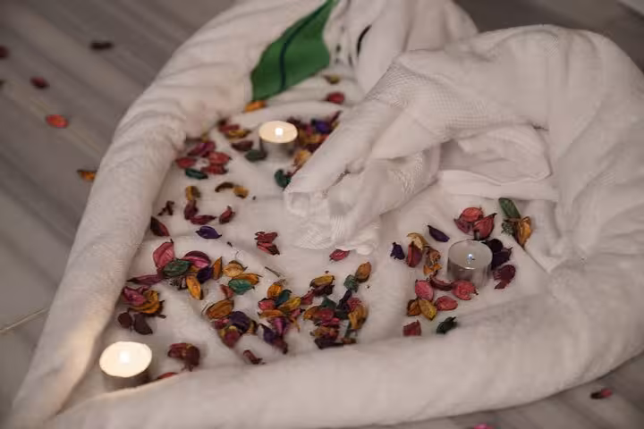 Romantic spa setup with rose petals, candles and towels for luxurious royal hammam and solo spa in Sharm El Sheikh
