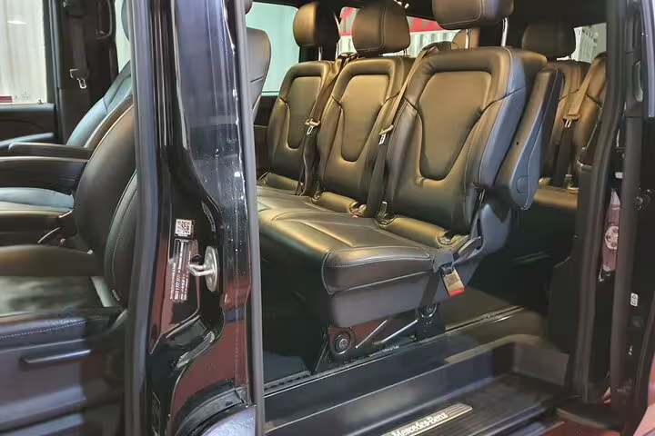 Luxury black van interior with leather seats for private hotel pickup transfer to Madrid Chamartin Station