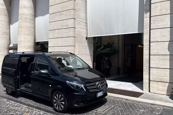 Luxury black van parked outside elegant building for Naples to Sorrento or Positano private transfer tour.