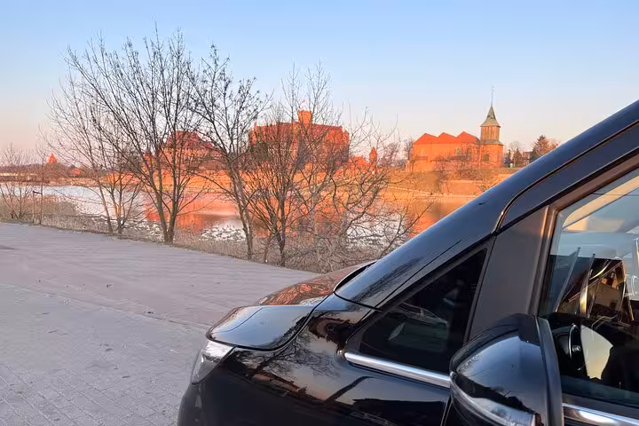Luxury black van parked near scenic Ravenna riverside, ideal for cruise terminal transfers to Bologna Airport.