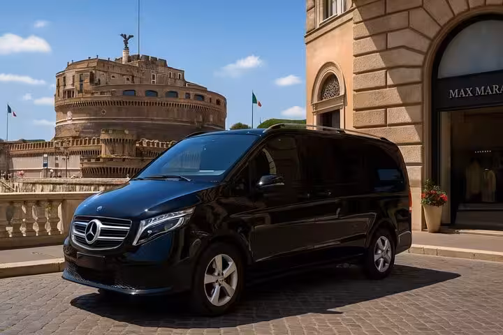 Luxurious black van parked near historic Castel Sant'Angelo in Rome, perfect for a full-day city tour experience.