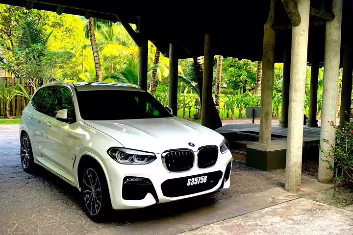 Luxury BMW SUV parked under a tropical canopy, showcasing premium options for Seychelles VIP Transport Services.