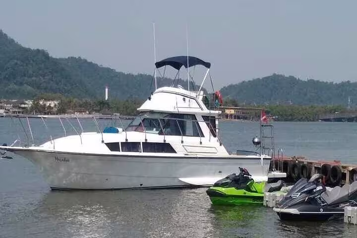 Luxury boat docked in Santos with jet skis, offering a full-day private tour experience with scenic views.