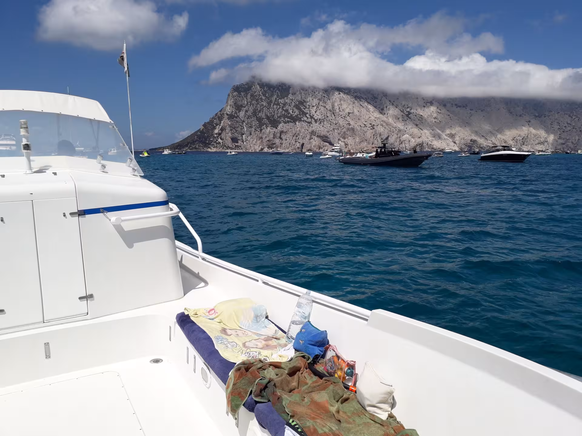 Luxurious boat cruising near Tavolara Island with clear blue skies on a Porto San Paolo tour.