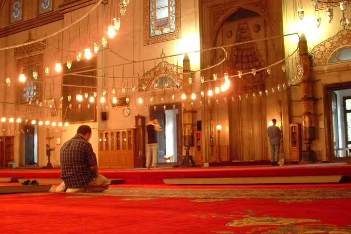Historic Cairo mosque interior with glowing lanterns and red carpets, curated luxury Cairo Four Seasons visit