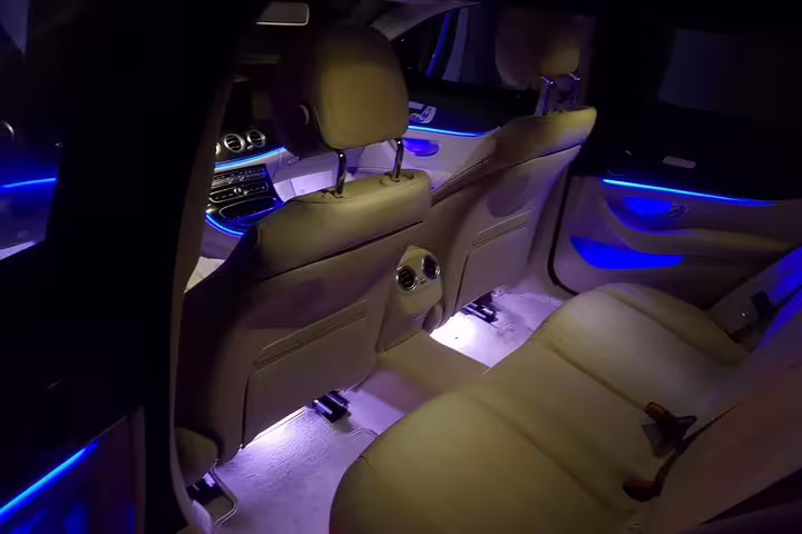 Spacious rear seats with blue ambient lighting in luxury car for private Valencia Airport transfer service