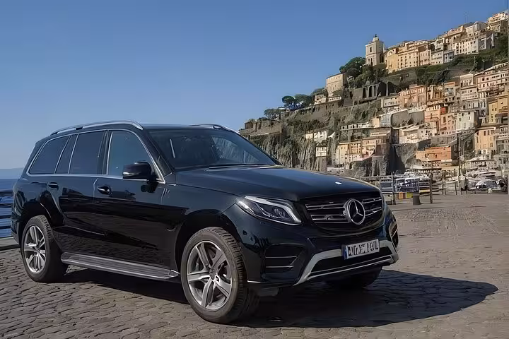 Luxury car parked with a stunning backdrop of Sorrento's historic architecture on a private Amalfi tour.