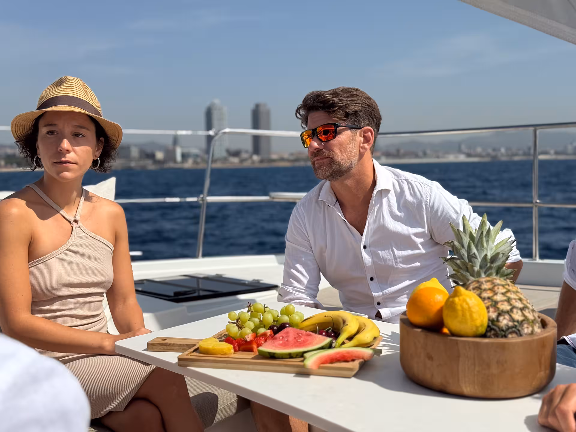 Private luxury catamaran Barcelona tour with fresh fruit platter and skyline views aboard Bali 4.2