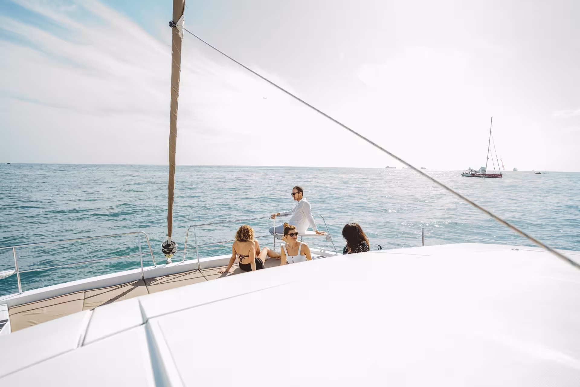 Friends relaxing on Bali 4.1 luxury catamaran during 2-hour private Barcelona sailing charter on the Mediterranean