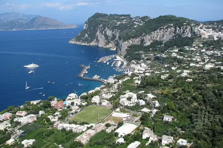 Aerial view of Capri marina and cliffs, ideal for a weekly luxury catamaran cruise along the Amalfi Coast, Italy