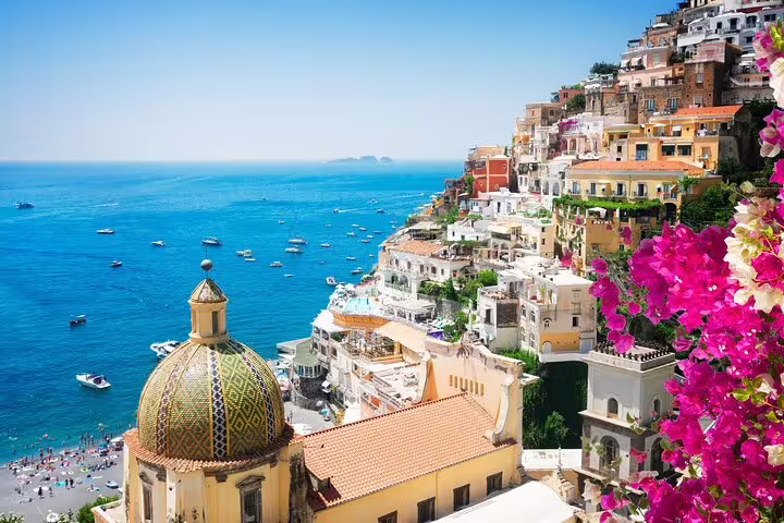 Weekly luxury catamaran cruise along Positano, passing pastel cliffside villas, church dome and boats on the Amalfi Coast