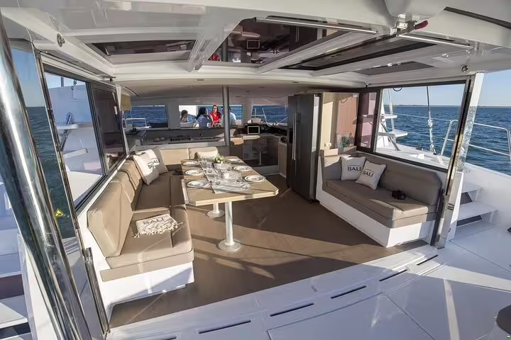 Spacious luxury catamaran interior with elegant dining setup, cruising the Mediterranean Sea on a Cyprus tour from Limassol.