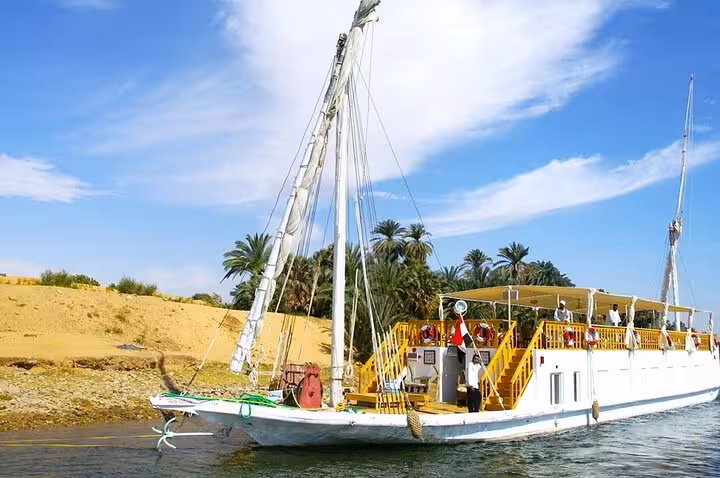 Traditional private luxury dahabiya cruising the Nile near palm-lined banks on 5 days 4 nights Abu Simbel tour